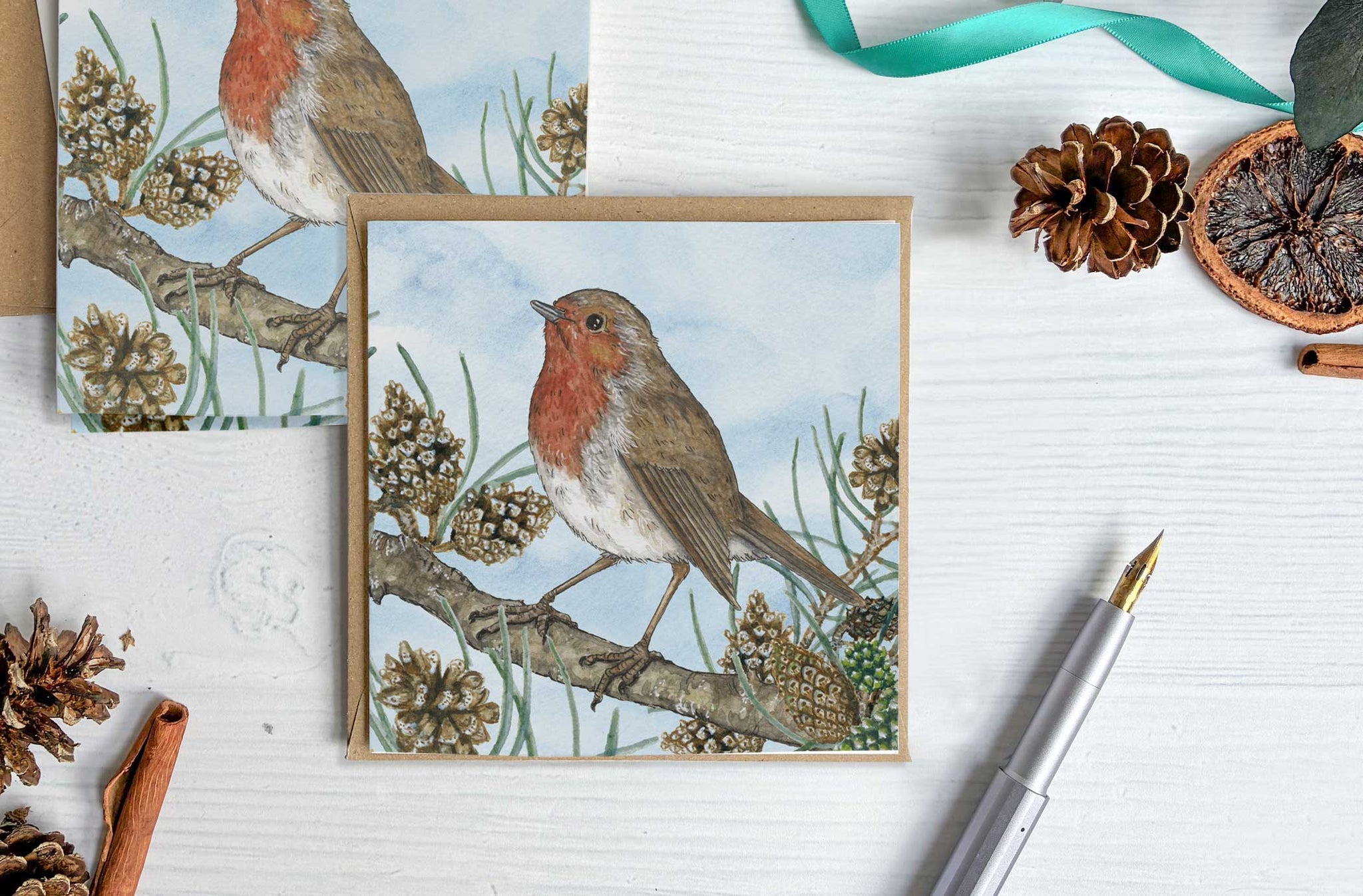 Card with a robin design on a white surface with decorative items