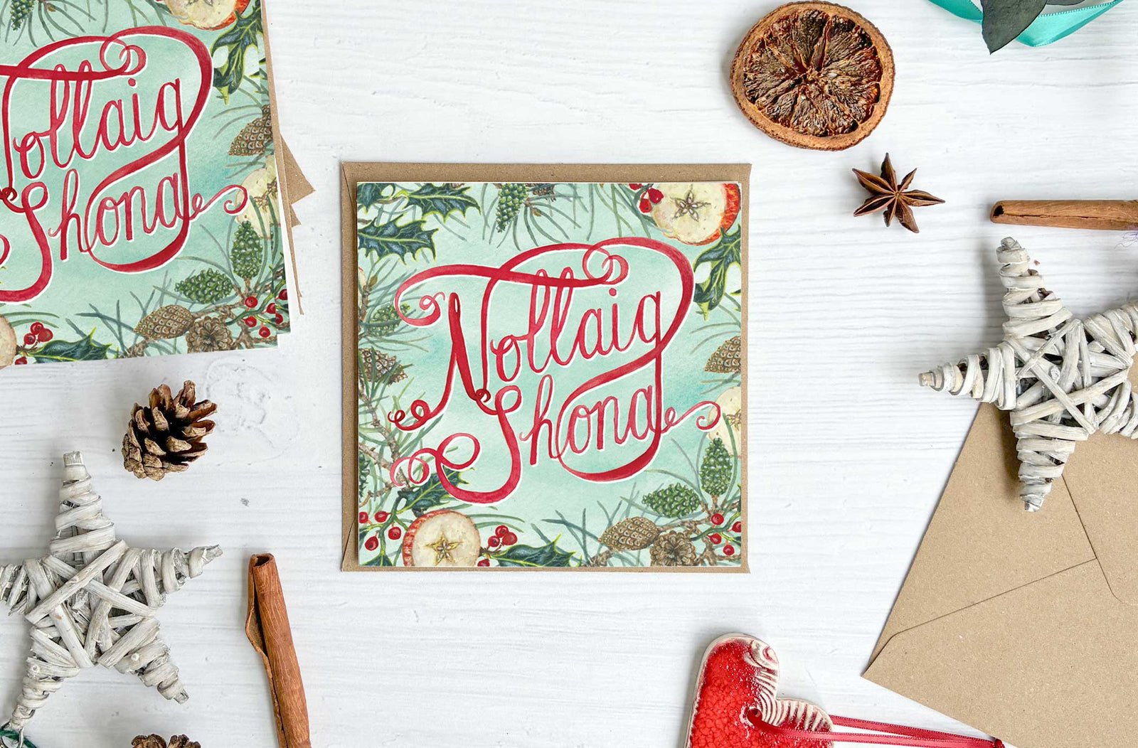 Nollaig Shona Irish Christmas-themed card with watercolour painted decorative elements on a white surface